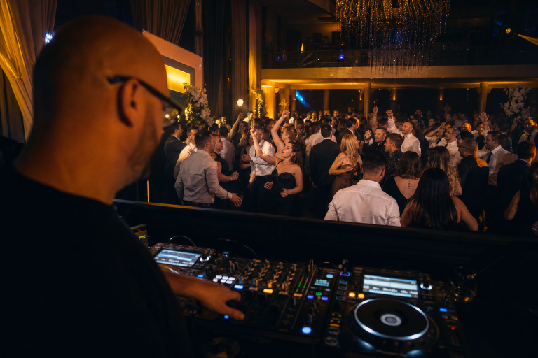 DJ urmărește reacțiile invitaților pe ringul de dans la o nuntă.