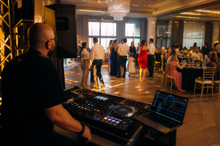 DJ urmărește reacția invitaților de toate vârstele la un botez, în timp ce ringul de dans se animă treptat.