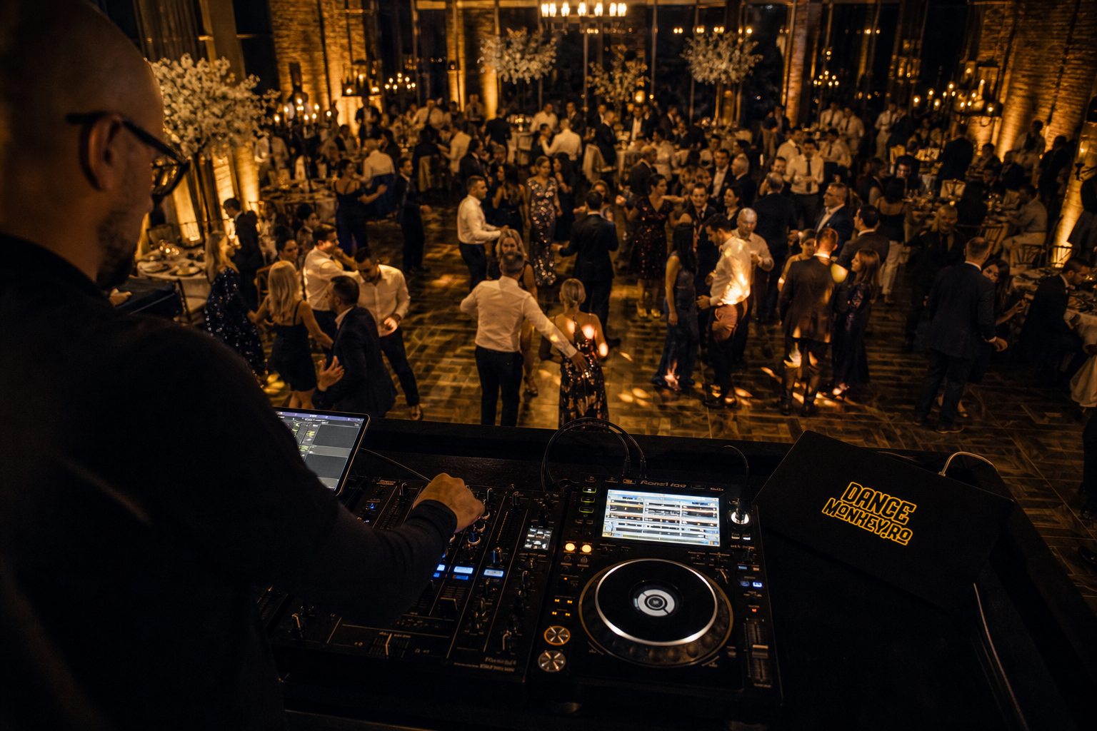 Invitați de generații diferite dansează, iar DJ-ul adaptează muzica la energia ringului.