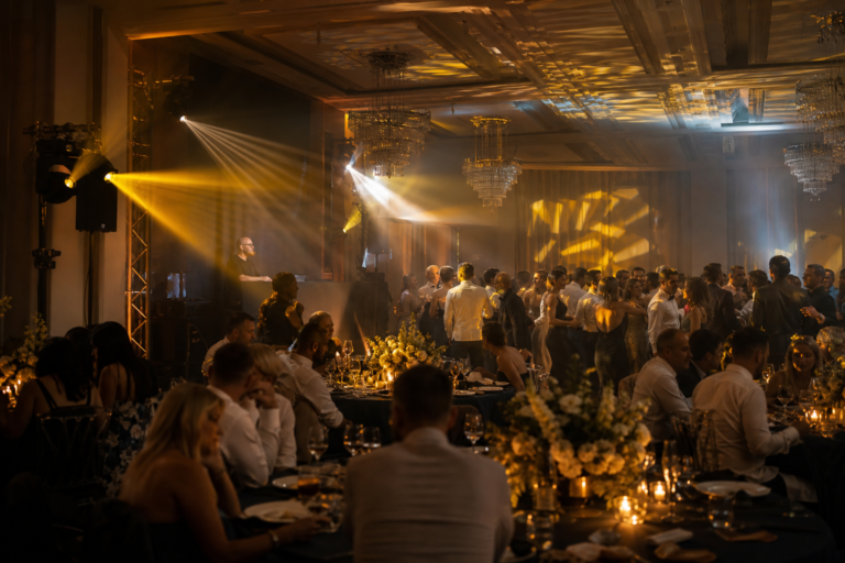 Invitați dansează și discută confortabil într-un salon de nuntă sonorizat echilibrat.